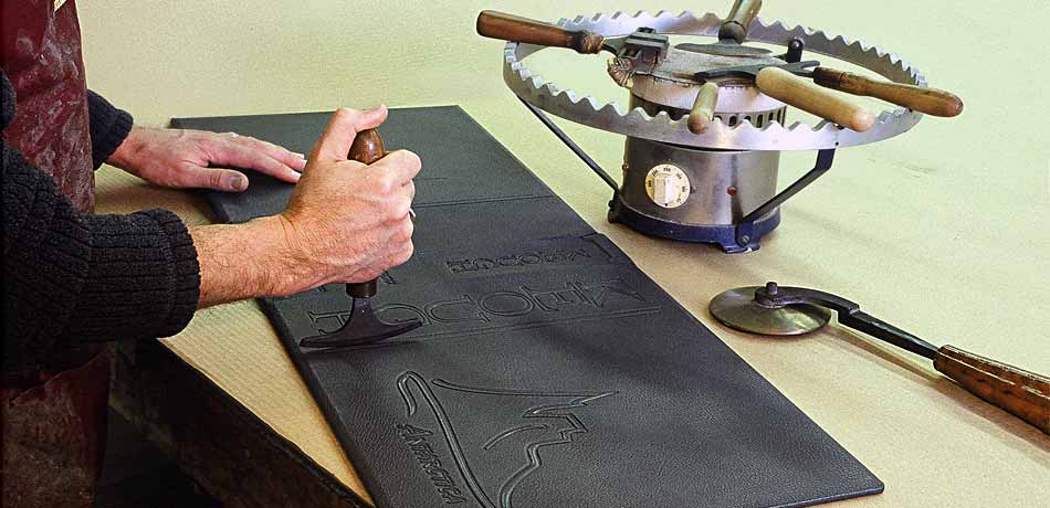 Master Binder Keith Felton uses hand-tools to decorate the leather covers of ANTARCTICA. A collection of these tools are kept warm on the heater called a Finishing Stove